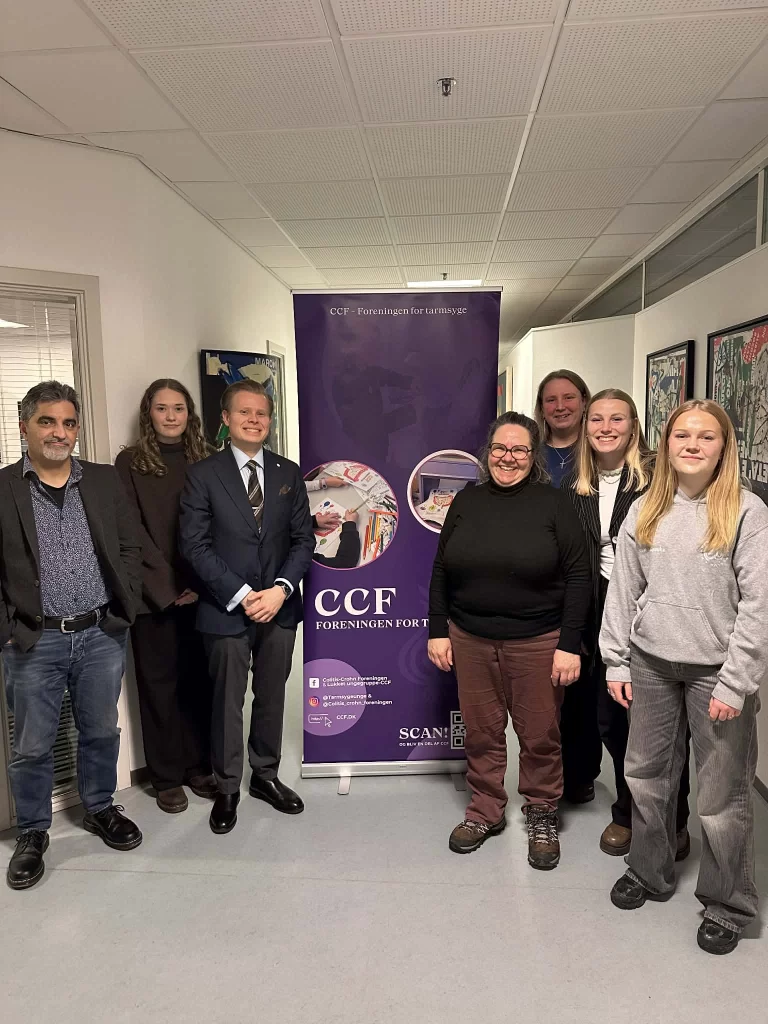 Frivillige fra CCF Lokalafdeling Fyn står samlet foran CCF roll-up banner til et arrangement.